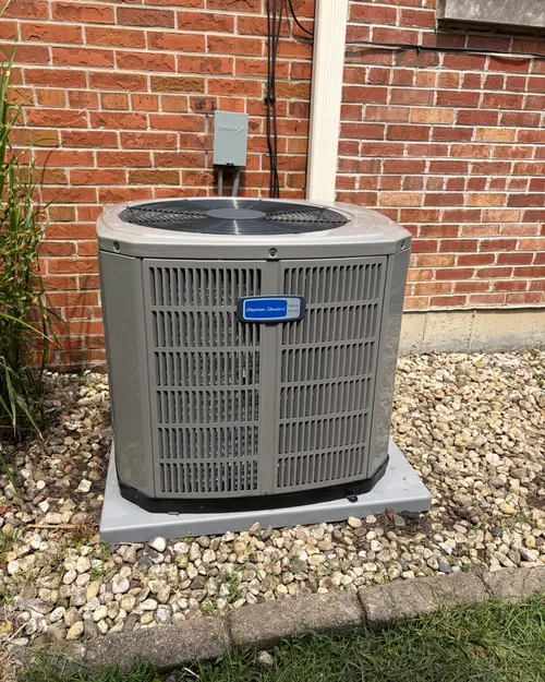 New outdoor air conditioner beside a brick home